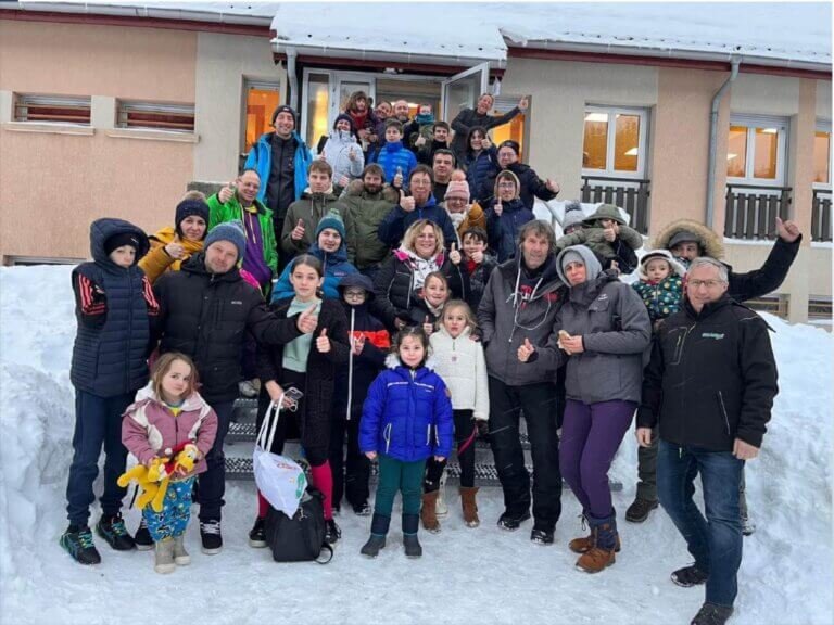 Groupe de parents et d'enfants sur des escaliers enneigés